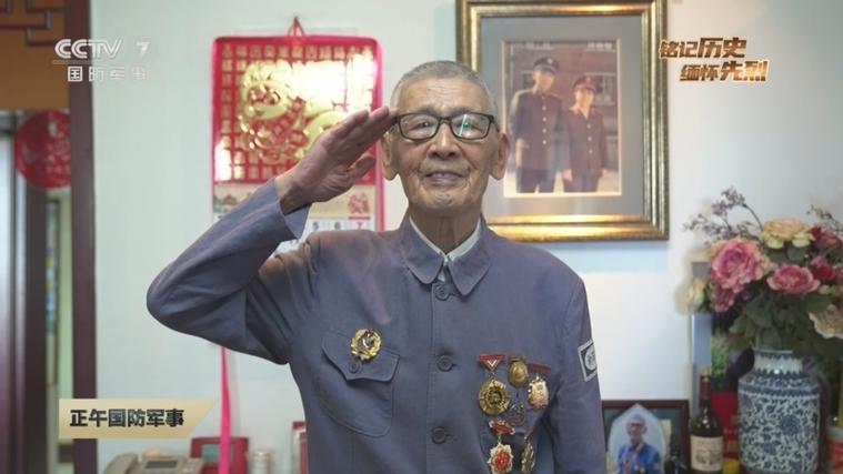 老人将电视正对烈士墓碑播阅兵