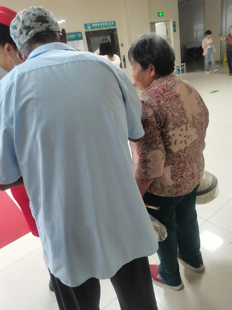 多名穿病号服老人医院门前干活